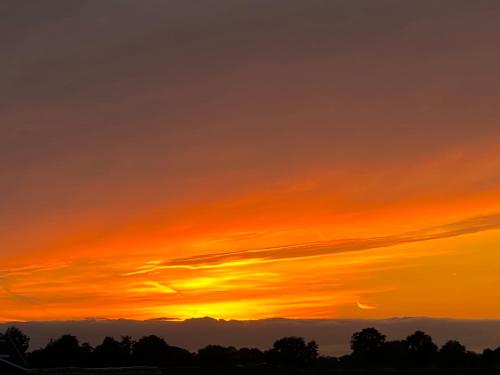 an orange sunset with clouds in the sky at Hotel-Eetcafé d'Olde Heerd in Balkbrug