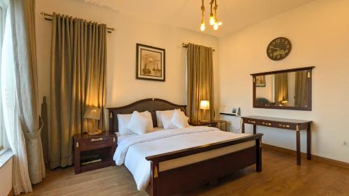a bedroom with a large bed and a clock on the wall at Haven Lodge Khaira Gali - Pine Ridge Residences #7 in Khaira Gali