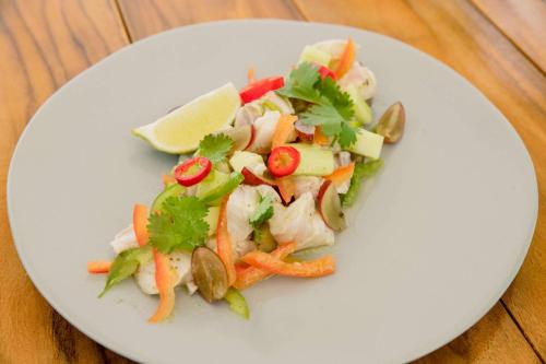 a white plate with a salad with shrimp and vegetables at Oceans Edge Key West in Key West