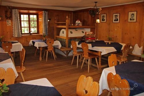 comedor con mesas, sillas y bañera en Gasthof Schluff, en Soprabolzano