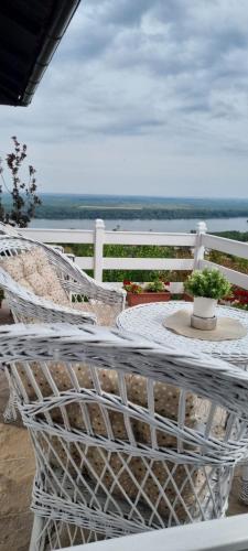 a white table and chairs on a porch with a view of the water at View Point House in Smederevo