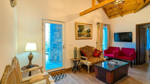 a living room with a red couch and chairs at Haven Lodge Khaira Gali - Pine Ridge Residences #7 in Khaira Gali