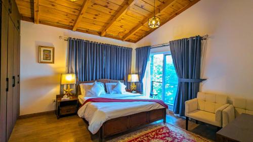 a bedroom with a bed and a chair and a window at Haven Lodge Khaira Gali - Pine Ridge Residences #7 in Khaira Gali