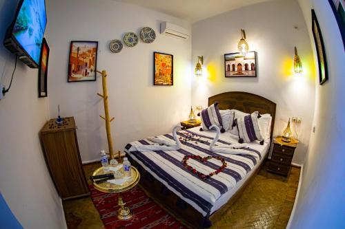 a bedroom with a bed and a tv in it at Riad Hikaya - Fes Story in Fès