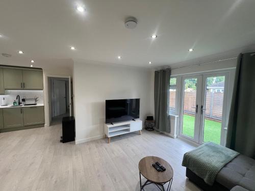 a living room with a couch and a tv at Rose Mews, Newly Refurbed Modern Interior with Garden in Edmonton