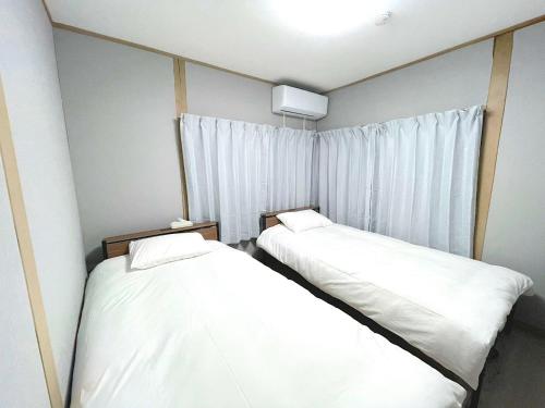 two beds in a small room with a window at Nagasaki - House - Vacation STAY 19522 in Nagasaki