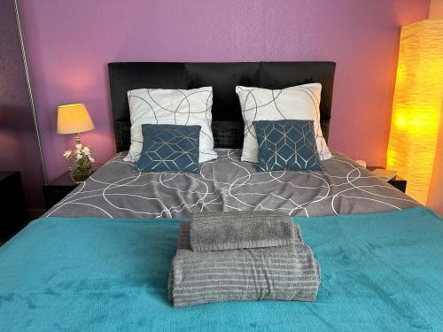 une chambre avec un grand lit avec des draps et des oreillers bleus dans l'établissement Superbe 3pièces, balcon, garage, clim, piscine, à Mougins