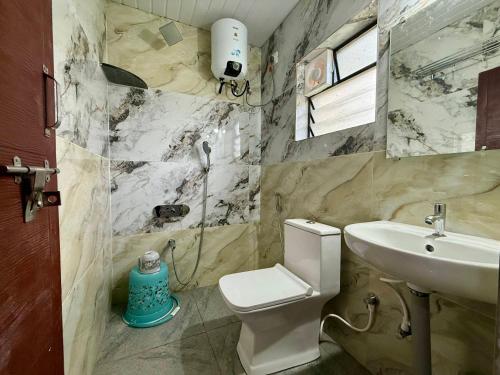 a bathroom with a toilet and a sink at Kanasu Residency in Malpe
