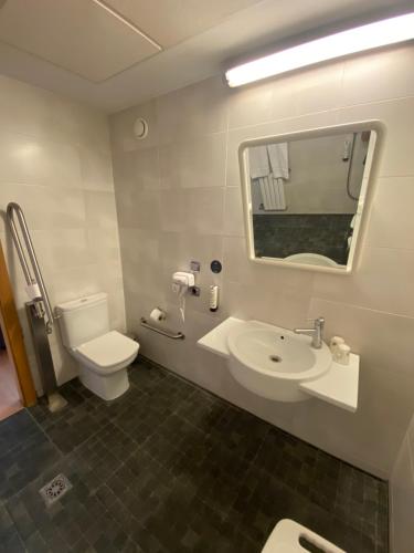 a bathroom with a sink and a toilet and a mirror at U Hotel Villa-Gomá in Zaragoza