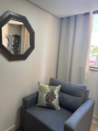 a blue couch in a room with a mirror at La Residence Elegante Flat Goiânia - Liah in Goiânia