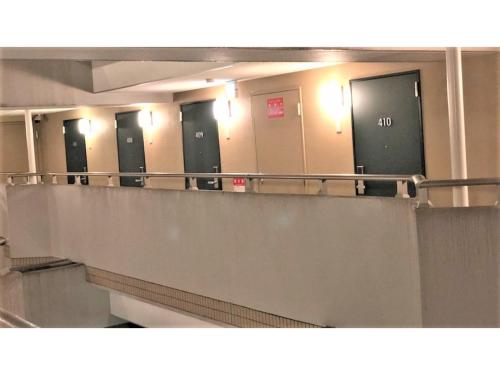 a row of stalls in a public bathroom with doors at Smile Hotel Nagoya Sakae - Vacation STAY 66752v in Nagoya