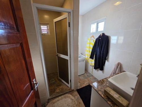 een badkamer met een wastafel, een toilet en een douche bij Mathoeralaan Appartement in Paramaribo