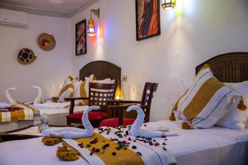 two beds in a room with swans on the bed at Riad Hikaya - Fes Story in Fès