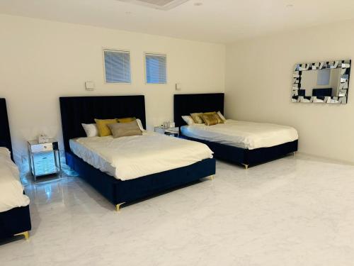 a bedroom with two beds and a mirror on the wall at Luxury Hills - Vacation STAY 19539 in Fukuoka