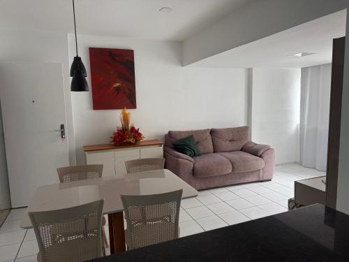 uma sala de estar com um sofá e uma mesa em lindo apartamento de frente para à praia de pajuçara em Maceió