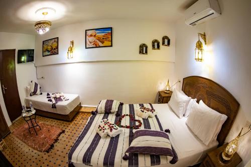 a hotel room with two beds with towels on them at Riad Hikaya - Fes Story in Fès