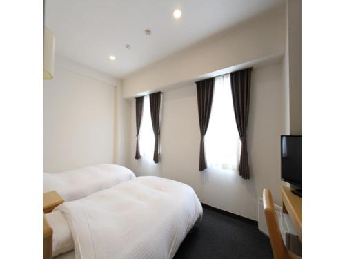 a hotel room with two beds and a television at Smile Hotel Yonezawa - Vacation STAY 67025v in Yonezawa