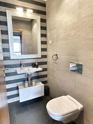 a bathroom with a sink and a toilet and a mirror at 3-marina Serena ocean-studio chic vue mer in Casablanca