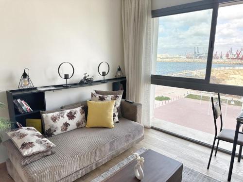 a living room with a couch and a large window at 3-marina Serena ocean-studio chic vue mer in Casablanca