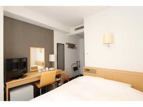 a bedroom with a bed and a desk with a computer at Smile Hotel Yonezawa - Vacation STAY 67022v in Yonezawa