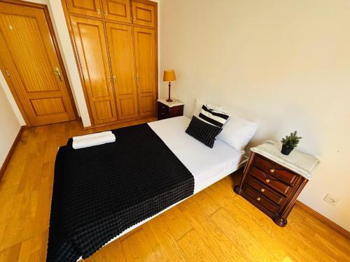 a bedroom with a bed and a wooden floor at Luxury apartment next Lisbon centre, super well connected in Queluz