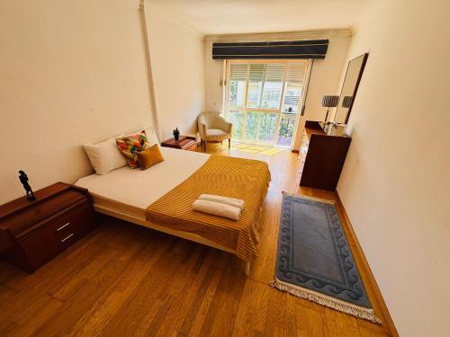 a bedroom with a large bed and a window at Luxury apartment next Lisbon centre, super well connected in Queluz