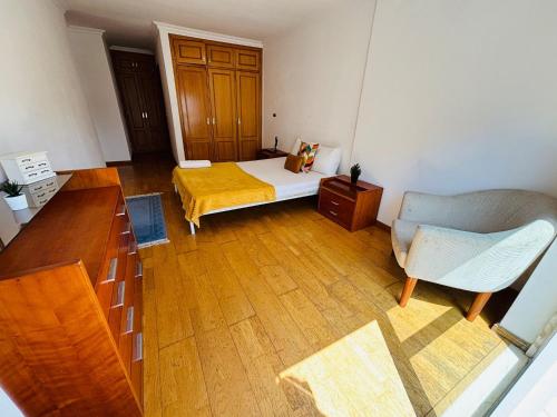 a small room with a bed and a chair at Luxury apartment next Lisbon centre, super well connected in Queluz