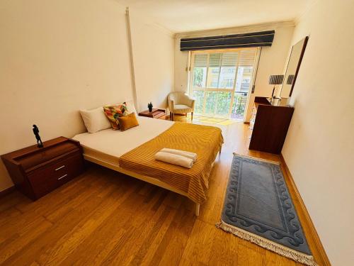 a bedroom with a bed and a large window at Luxury apartment next Lisbon centre, super well connected in Queluz