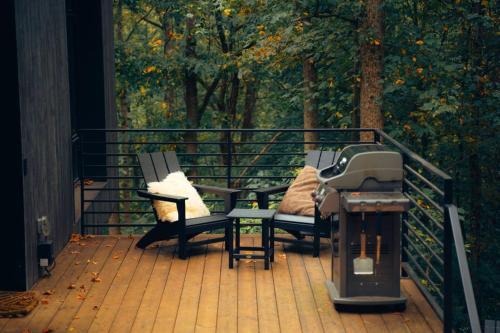 two benches sitting on a deck with a grill at Idyll Reserve - Hocking Hills in South Bloomingville