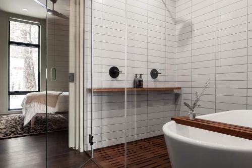 a bathroom with a shower and a tub and a sink at Idyll Reserve - Hocking Hills in South Bloomingville