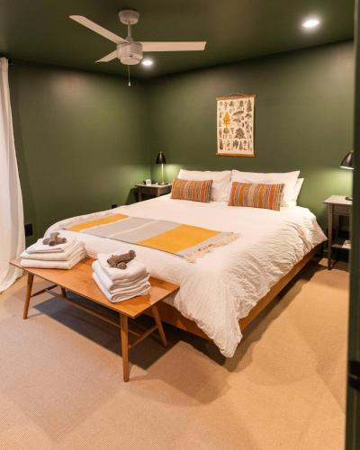 a bedroom with a large bed with green walls at Idyll Reserve - Hocking Hills in South Bloomingville