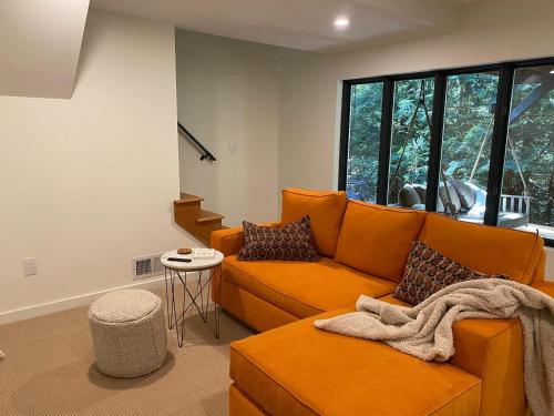 a living room with an orange couch and a table at Idyll Reserve - Hocking Hills in South Bloomingville