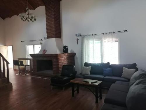 a living room with a blue couch and a fireplace at Cabaña con picina Panorámica in Tonalá