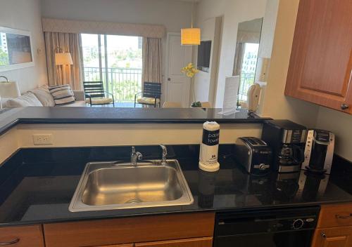 a kitchen counter with a sink and a living room at The Point Hotel & Suites - 503 Luxury - Pool view - Close to Universal in Orlando