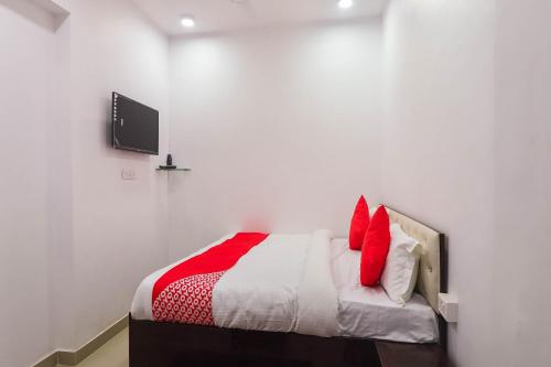 a bedroom with a bed with red pillows on it at Super HOTEL O CK INN in Charbagh