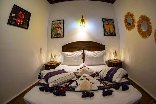 a bedroom with a bed with pillows on it at Riad Hikaya - Fes Story in Fès