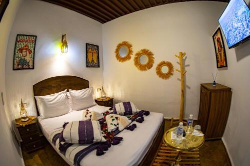 a bedroom with a bed with two pillows at Riad Hikaya - Fes Story in Fès