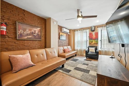 a living room with a couch and a brick wall at Heart of Downtown Delight in Philadelphia