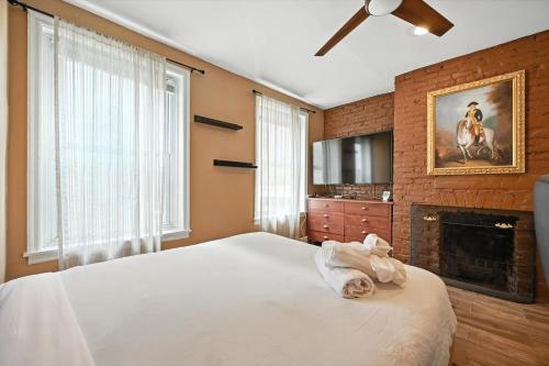 a bedroom with a white bed with a fireplace at Heart of Downtown Delight in Philadelphia