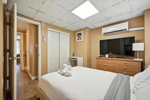 a bedroom with a white bed and a tv at Heart of Downtown Delight in Philadelphia