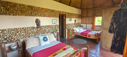 a bedroom with two beds in a room with a wall at Agandi Uganda Eco-lodges in Bwindi
