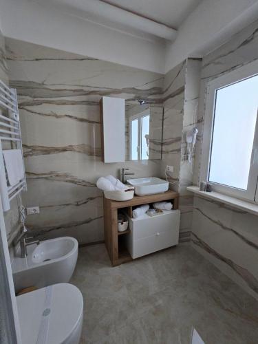 un bagno con due wc, un lavandino e uno specchio di La Piuma Cagliari a Cagliari