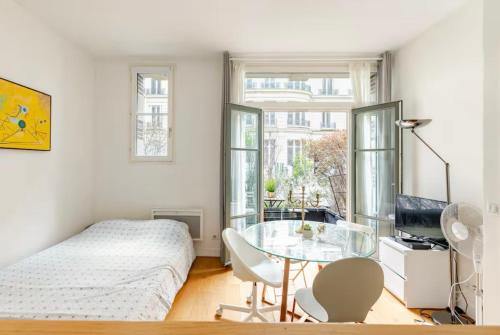 une chambre avec un lit et une table en verre dans l'établissement Beautiful apartment with terrace in Paris 8, à Paris