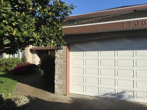 a garage door on a house with a driveway at Vancouver Pacific Guest House in Richmond