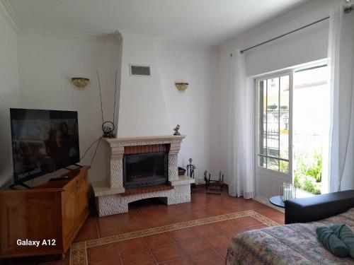 a living room with a fireplace and a tv at Marcio's Home in Fernao Ferro