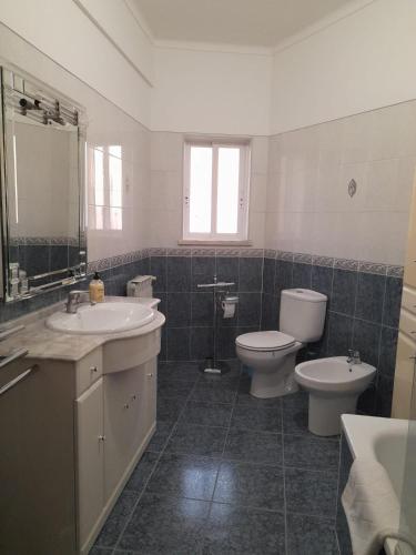 a bathroom with a toilet and a sink and a toilet istg at Marcio's Home in Fernao Ferro