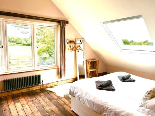 a bedroom with two beds and two windows at Deer Den timber clad cabin with hot tub, up private lane in Cullompton