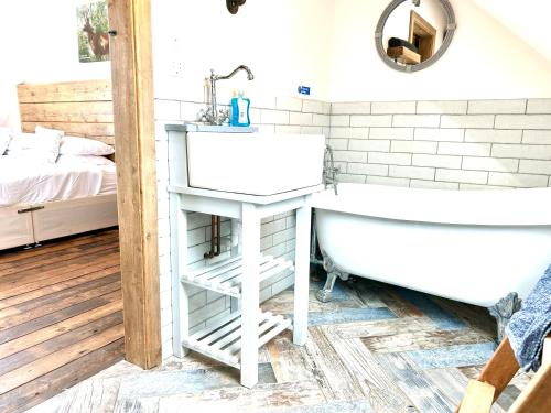 a bathroom with a sink and a bath tub at Deer Den timber clad cabin with hot tub, up private lane in Cullompton