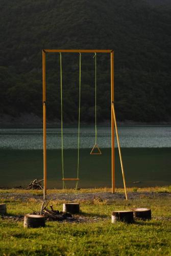 an empty swing set on the beach with the water at Cottage Naiosi in Pshavi 