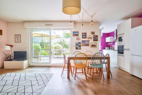 eine Küche und ein Esszimmer mit Tisch und Stühlen in der Unterkunft Grand et charmant appartement familial, 3 chambres, et moderne avec grand jardin et parking privatif aux portes de Paris in La Garenne-Colombes